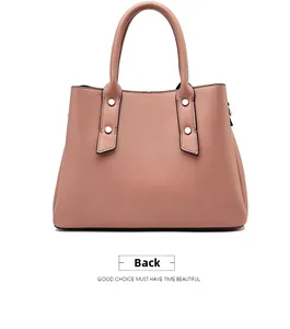 Detail view of the back of this dusty pink faux leather handbag with silver rivets