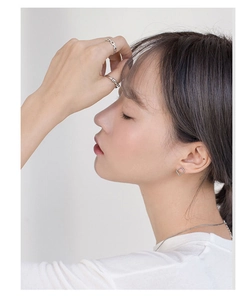 Modella asiatica con anello a nodo in argento S925 e set di gioielli geometrici eleganti