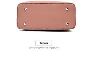 Bottom view of mauve leather handbag showing silver metal studs and detailed stitching
