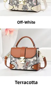 Detail of vintage paisley print handbag with metal hardware and adjustable strap