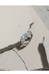 Makroaufnahme von strukturiertem Silberring mit Mondstein und blauen Zirkonia-Details