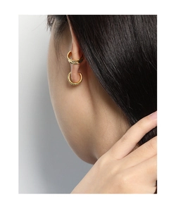 Gros plan détaillé d'une boucle d'oreille anneau et d'un faux piercing dorés minimalistes
