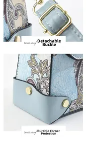 Detail of light blue paisley handbag showing detachable gold clasp and durable corners