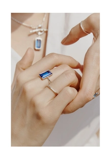 Gros plan d'une bague en argent S925 ornée d'une pierre précieuse bleu foncé