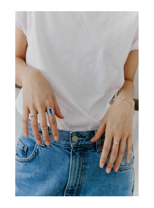 Gros plan de bagues en argent S925 avec zircon bleu rectangulaire sur la main du mannequin
