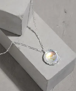 Detail of S925 silver necklace with moonstone pendant on minimalist grey base