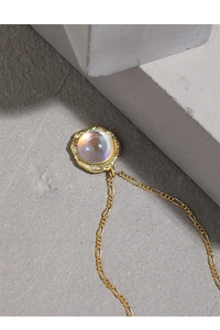 Macro shot of S925 silver gold-plated necklace with iridescent moonstone and hammered finish