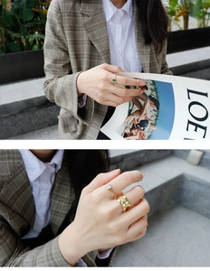 Detalle de anillo con circón verde cuadrado y anillos dorados en capas para mujer