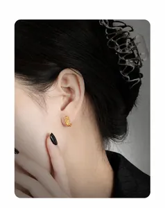 Detailed view of gold lava texture earrings featuring irregular hammered metal surface