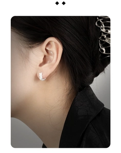 Macro detail of silver crescent moon hoop earrings with pavé set zirconia stones