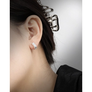 Irregular lava texture S925 sterling silver hoop earrings worn by a model in cold tone