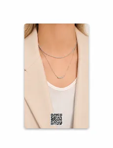 Detail einer silbernen Halskette mit funkelnder Tenniskette und langem Zylinder-Anhänger