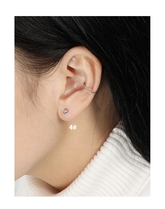 Detail van een minimalistische S925 zilveren bolletjes oorknop en touwtextuur ear cuff