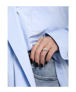 Close-up of S925 sterling silver moonstone ring and textured wide band on a model hand
