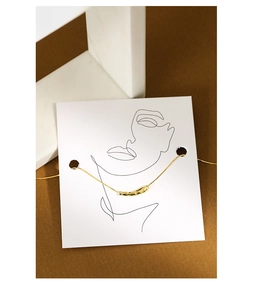 Detailaufnahme der goldenen Tropfenkette mit Schlangenkette auf Kunstkarte