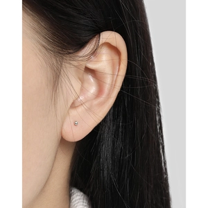 Minimalistische S925 sterling zilveren kleine ronde kraal oorknopjes op een vrouwenoor