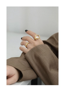 Close-up of S925 silver gold-plated ring with white crystal and lava texture