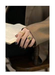 Detail of vintage gold rings with natural labradorite stone and lava texture on fingers