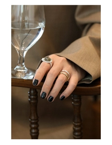 Detail of stacked S925 sterling silver rings with texture and green crystal stone