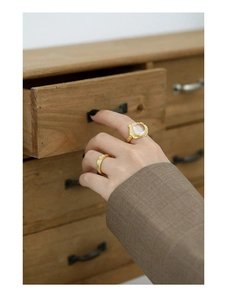 Detail of S925 silver gold rings featuring a white crystal and textured lava band design