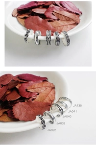 Detail of vintage silver rings set with rose and braided patterns in stackable styles