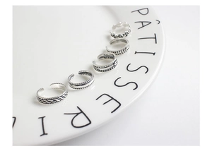 Macro view of five vintage silver rings showing intricate textures and S925 hallmark
