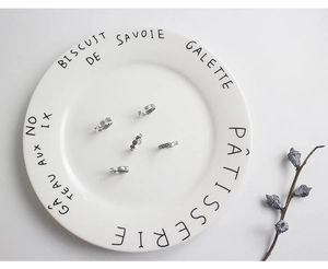 Detailed view of vintage S925 sterling silver hollow twisted open rings on a ceramic tray