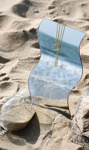 Close-up of S925 silver OT buckle necklaces on a beach mirror with sea reflection