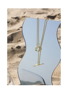 Detailed view of golden S925 silver bead necklace with artistic toggle clasp on mirror sand