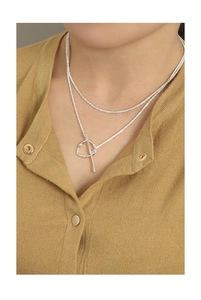 Close-up of S925 silver OT buckle necklace worn on a yellow knit sweater for a modern look