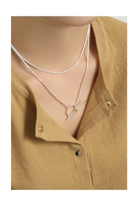 Detail of a layered S925 sterling silver necklace with T-bar clasp on a knit sweater