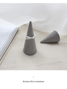 Minimalist S925 sterling silver triple interwoven ring displayed on a gray cone stand