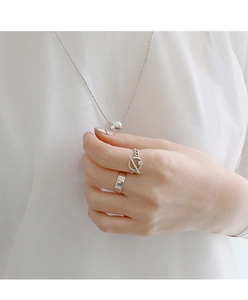 Gros plan sur une bague large en argent et une bague à boucle OT avec diamant sur un mannequin
