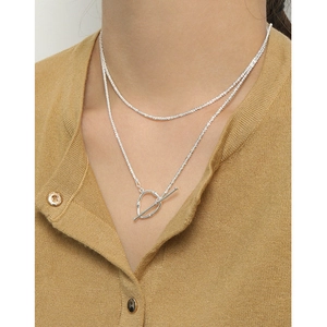 S925 sterling silver layered necklace with heart-shaped OT buckle on mustard yellow fabric