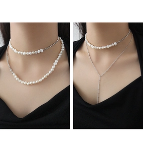 Dettaglio della collana con perle d'acqua dolce barocche e catena a sfere d'argento a strati