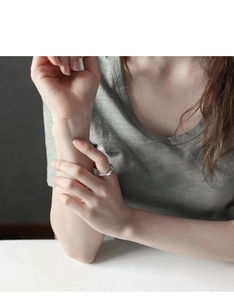 Close-up of a minimalist S925 sterling silver multi-layered crossover ring on a finger