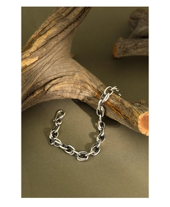 Close-up of retro S925 sterling silver chain bracelet with S-hook on driftwood