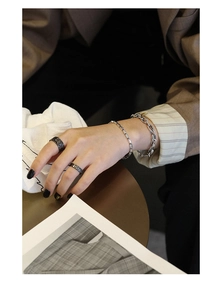 Detail of vintage Thai silver chains and textured rock-style rings on a model hand