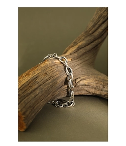 Detail of chunky silver chain bracelet with polished links on rustic wood branch