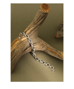 Macro detail of retro S925 silver chain bracelet on a textured wood branch