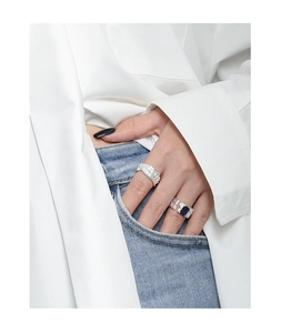 Detail of irregular silver rings with blue rectangle stone on denim pocket background