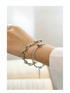 Detail of layered S925 sterling silver chain bracelets with a black square gemstone