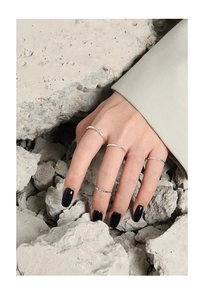 Detalle de cuatro anillos minimalistas de plata de ley S925 de 1,2 mm con diseño ondulado