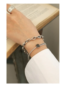 Close-up of vintage S925 silver chain bracelet set with black gemstone and star engraved ring
