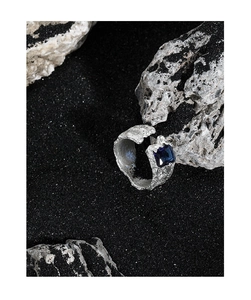 Detail of irregular textured silver ring with a deep blue rectangular zircon stone