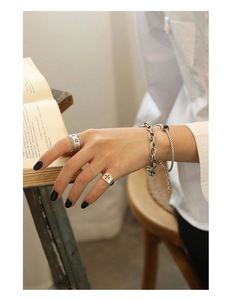Retro S925 sterling silver chain bracelets and vintage rings set on an open book