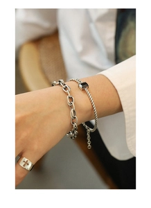 Close-up of retro silver chain bracelets and cross ring set on a model wrist