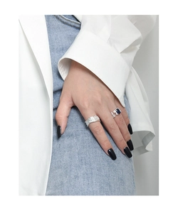 Close-up of a wide hammered texture silver ring and a blue zircon open ring set on a hand