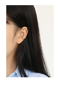 Detail van gouden ear cuffs op model met minimalistische geometrische metalen afwerking