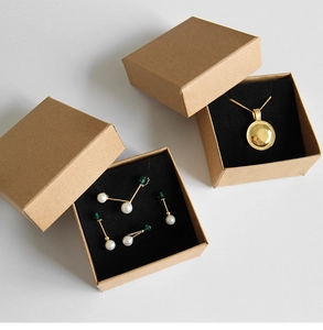 Bovenaanzicht van gouden ketting en parel sieraden set in kraftpapier geschenkdozen